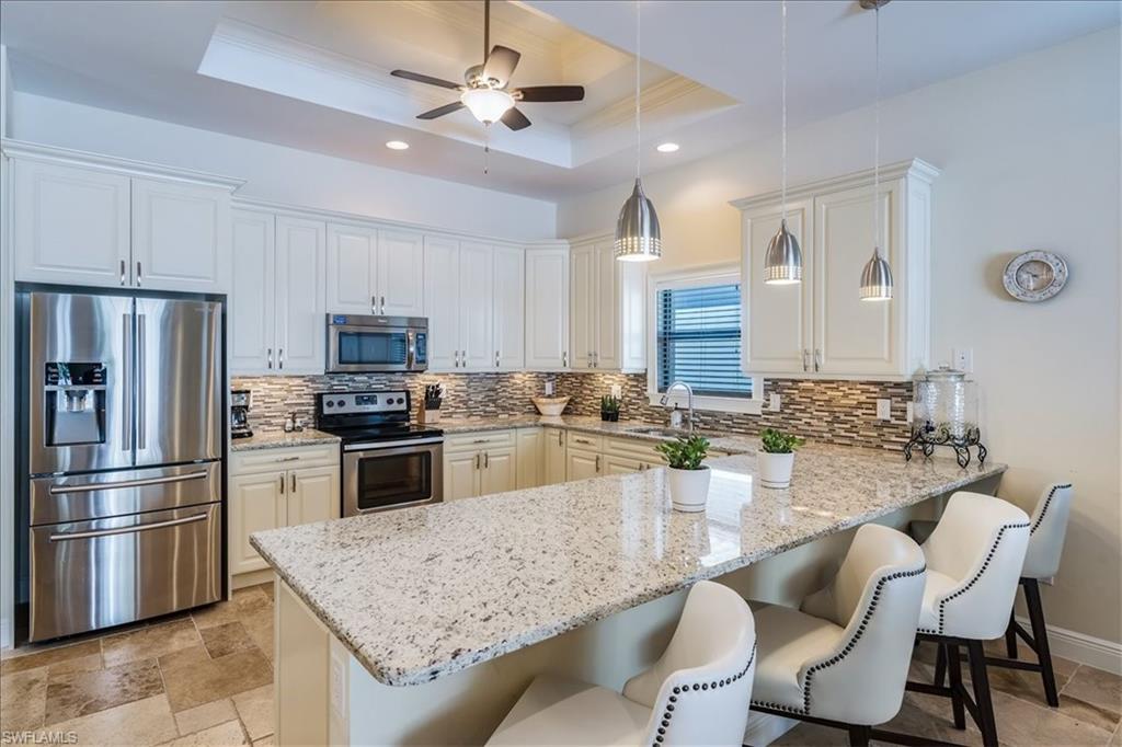 a kitchen with stainless steel appliances granite countertop a stove refrigerator sink and cabinets