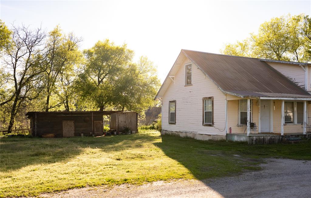 a front view of house with yard and trees in the background