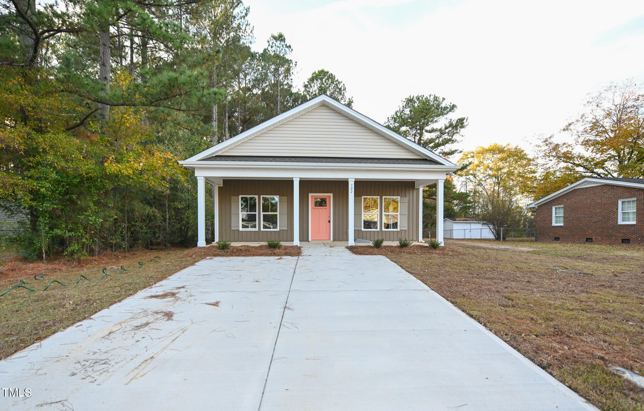 a view of a house with a yard and large tree