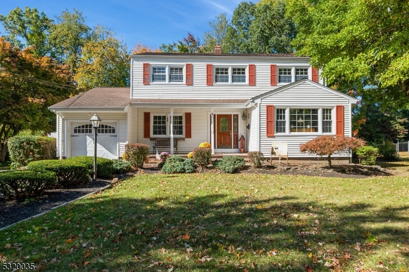 a front view of a house with yard and green space