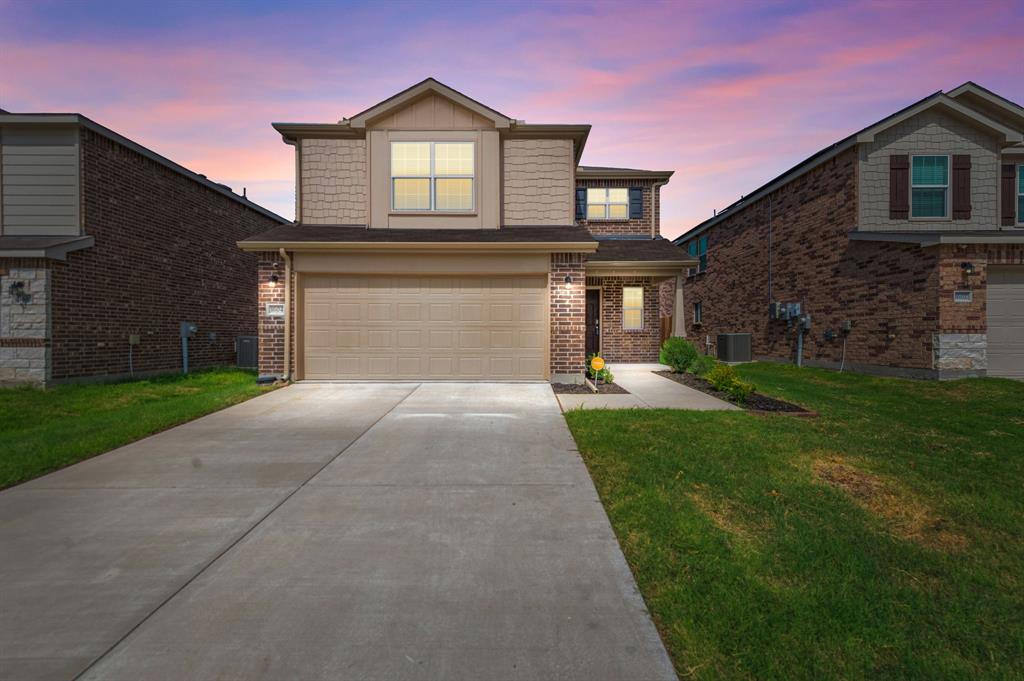 a front view of a house with a yard and garage