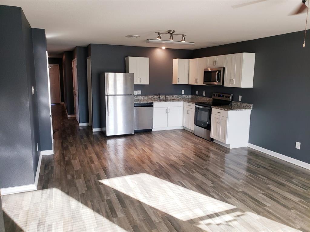 a kitchen with stainless steel appliances kitchen island a refrigerator and a stove top oven