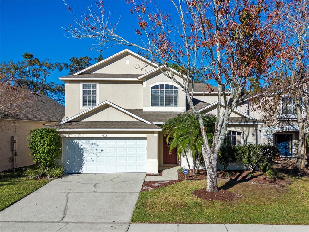 a front view of a house with a yard and garage