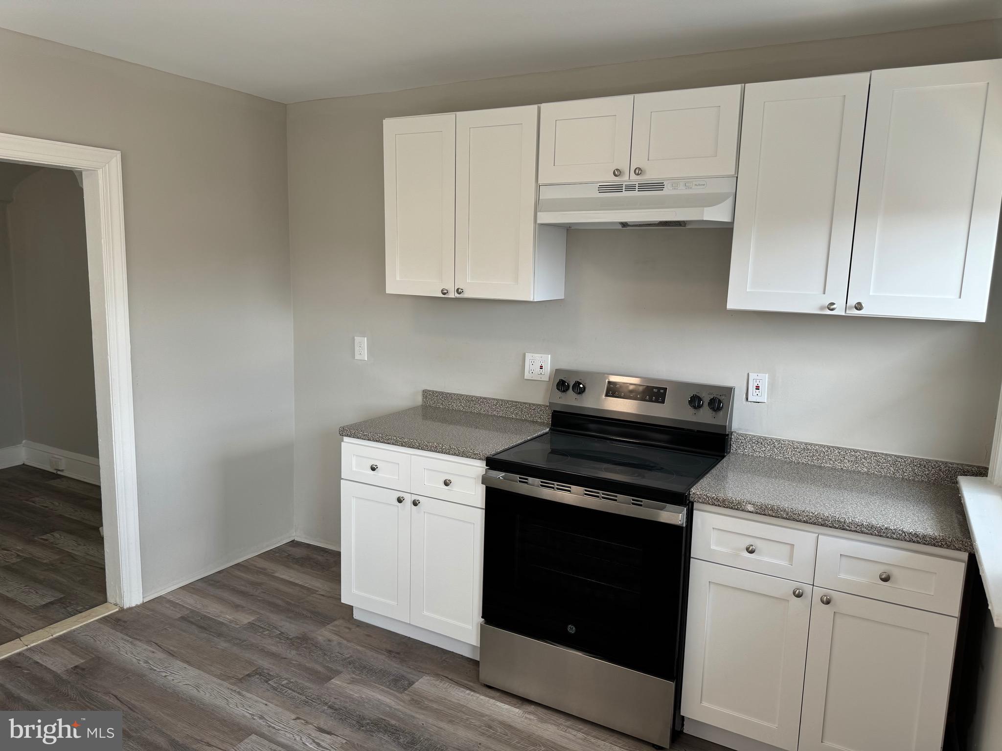 a kitchen with granite countertop white cabinets and black appliances