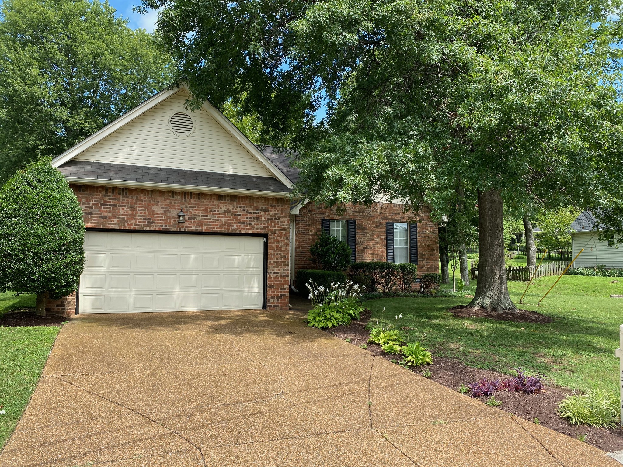 a front view of a house with a yard and trees