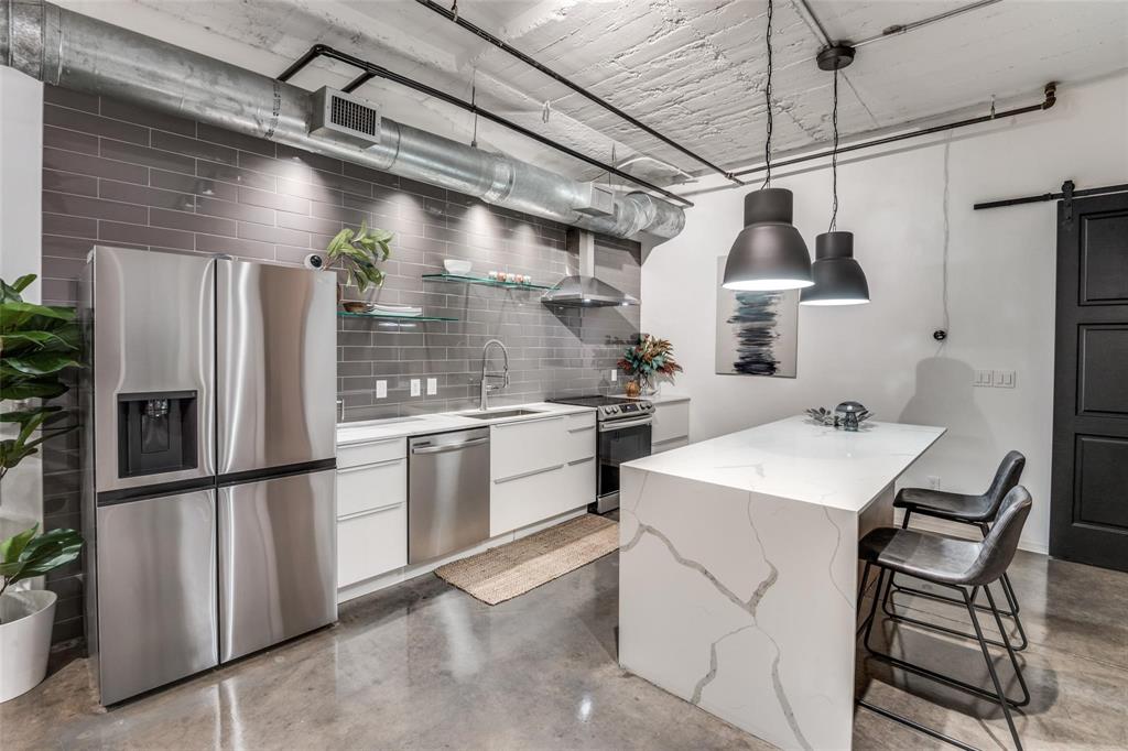 a kitchen with refrigerator and chairs