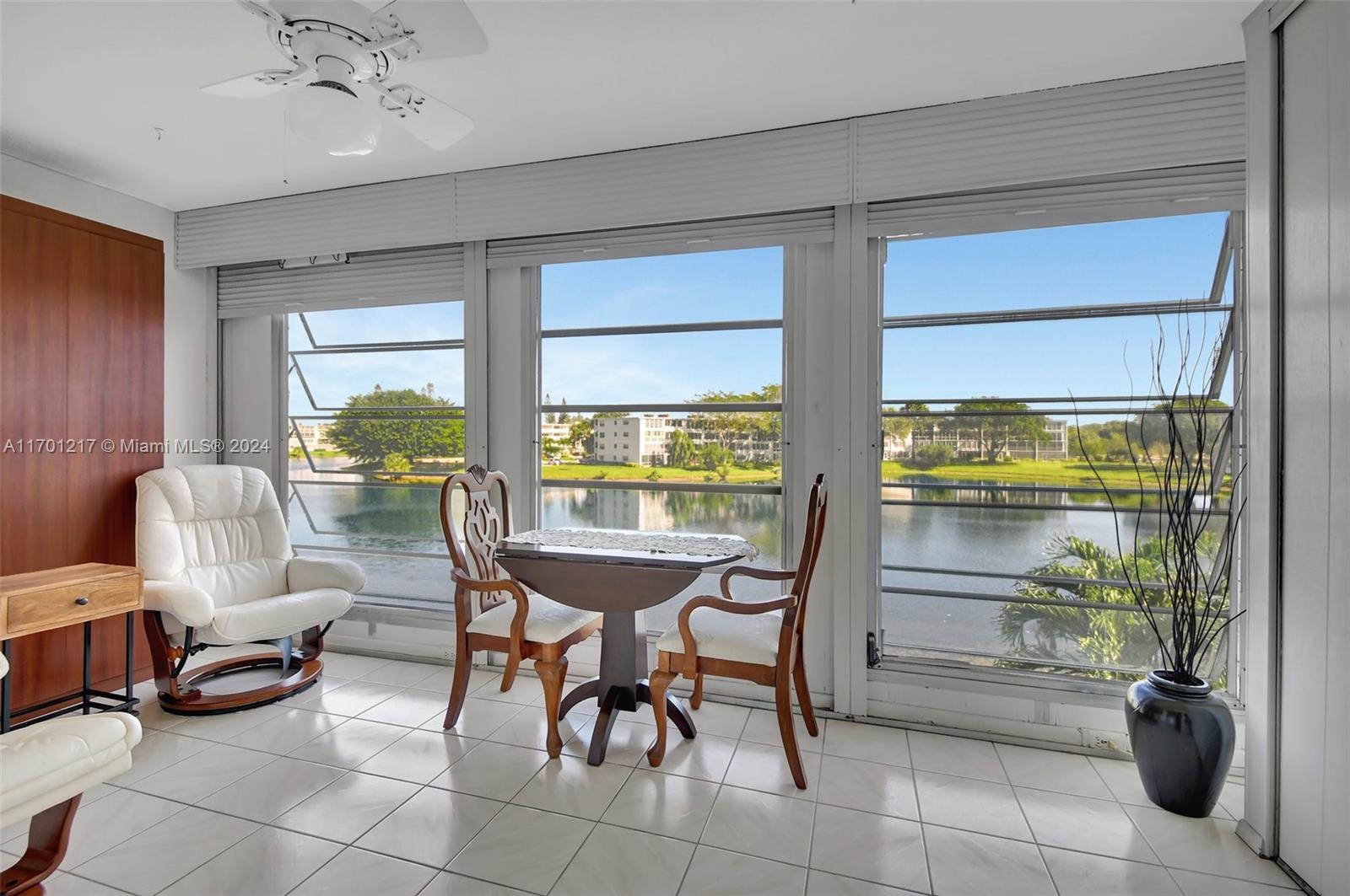 a dining room with furniture and a floor to ceiling window