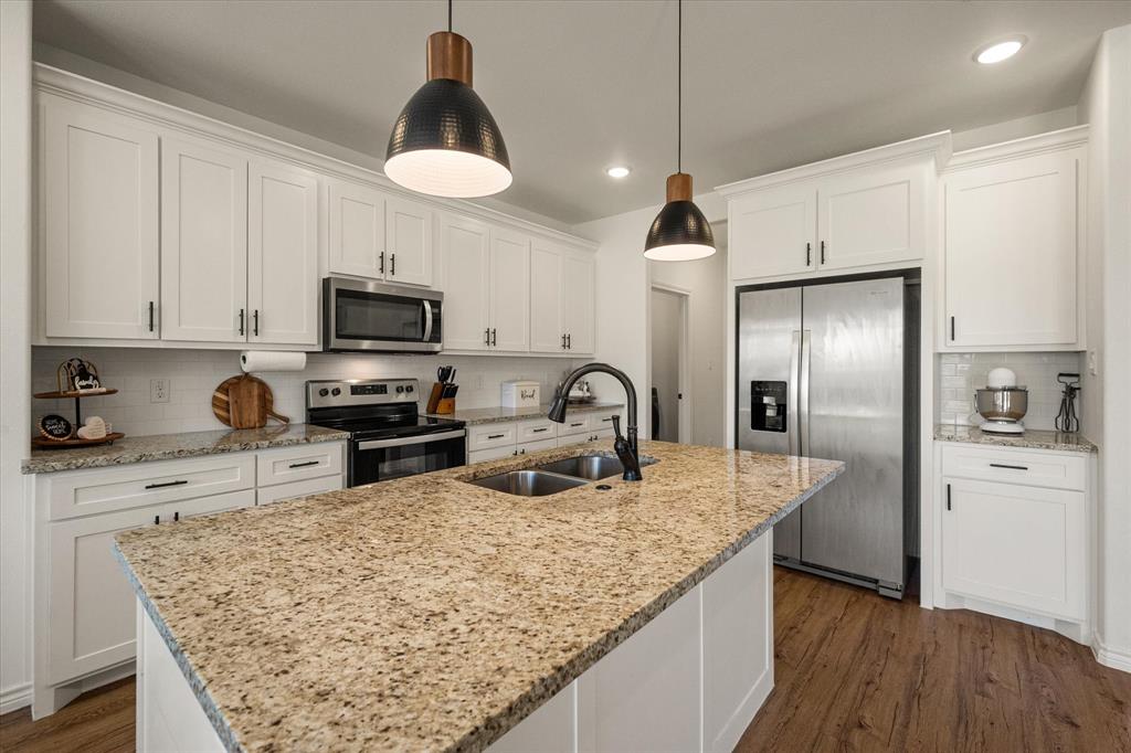 a kitchen with stainless steel appliances granite countertop a sink refrigerator and microwave