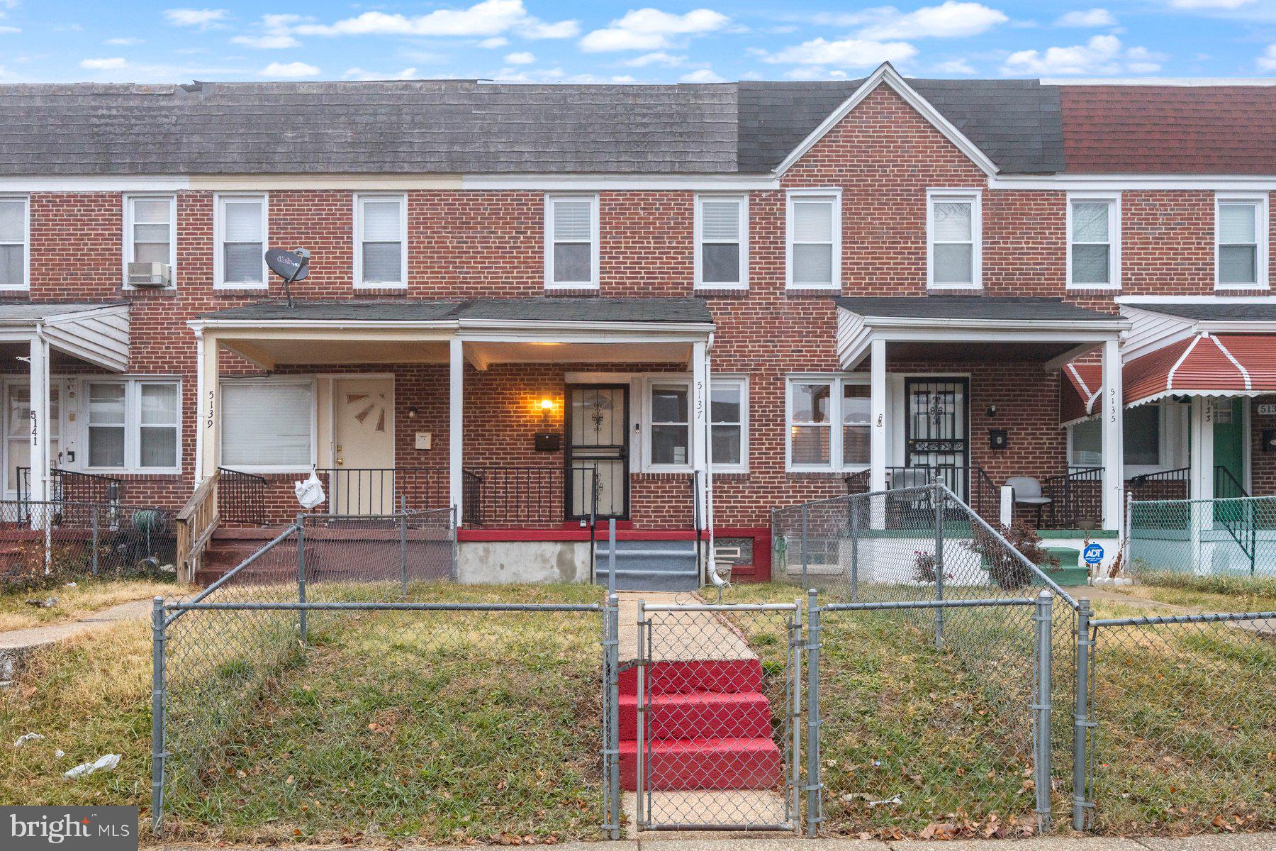 front view of a brick house with a yard