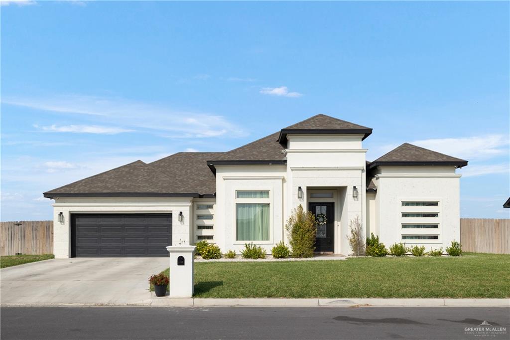 Prairie-style house with a garage and a front lawn