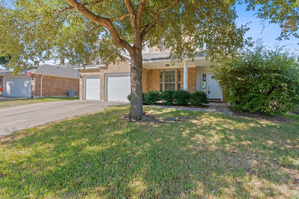 a front view of a house with a yard and trees