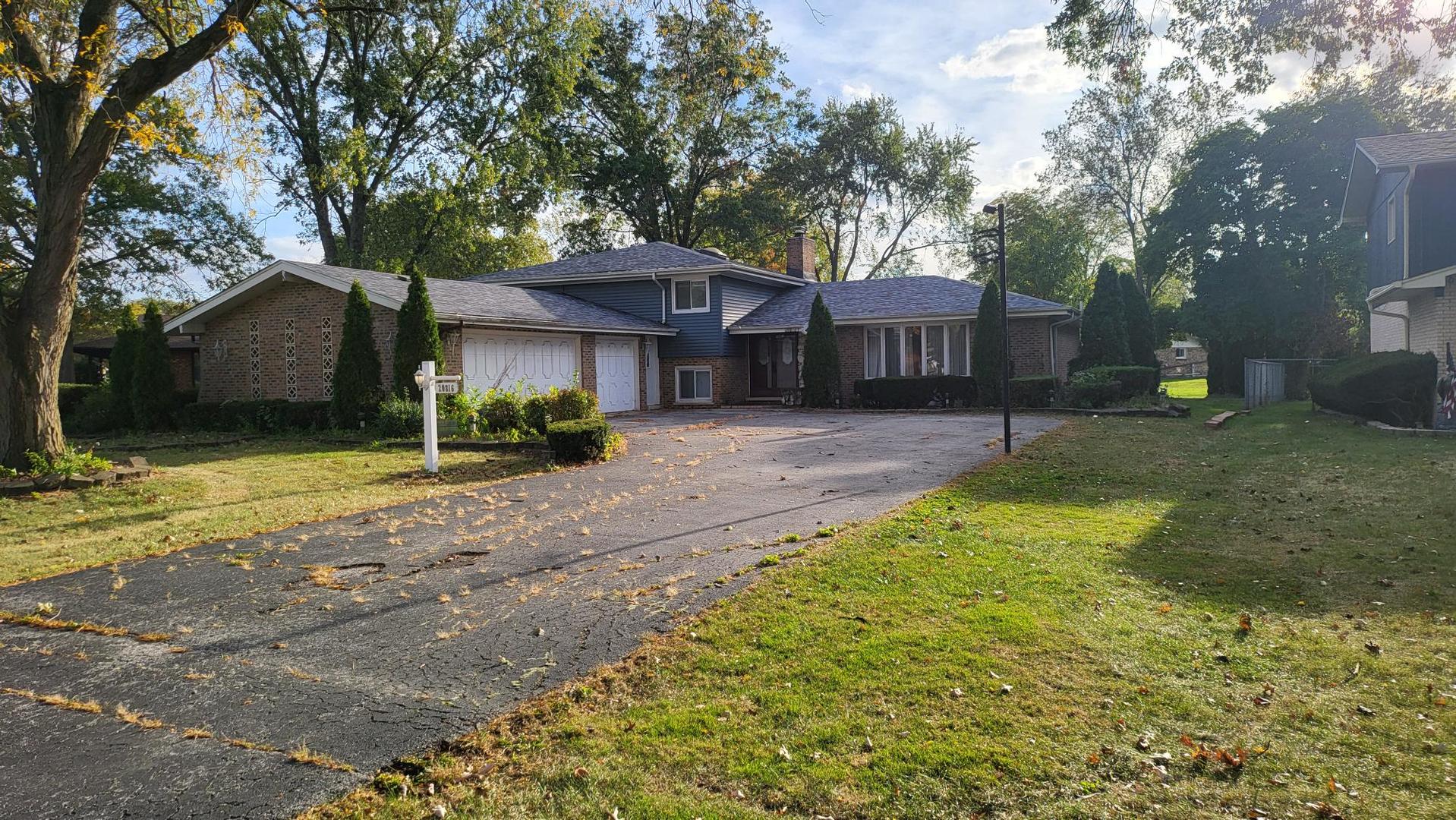 a front view of a house with a yard and trees