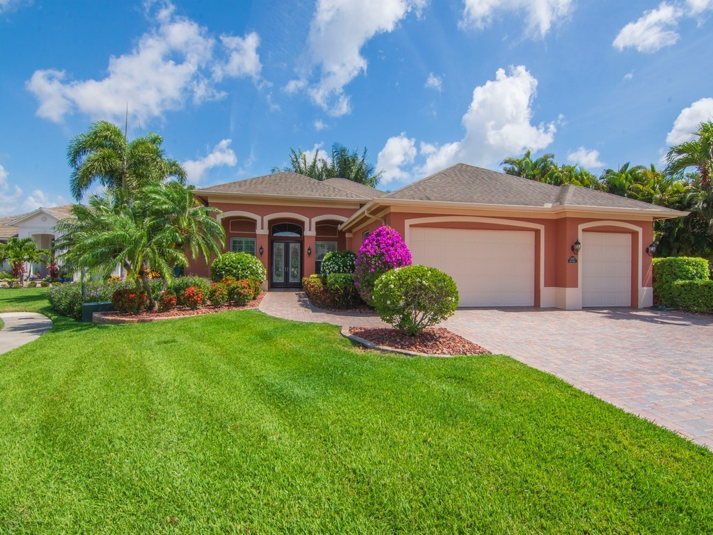 a front view of a house with a yard and potted plants