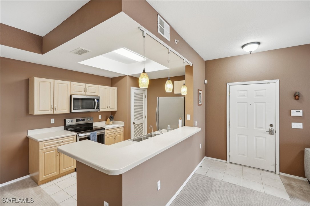 a kitchen with a sink a counter top space and stainless steel appliances