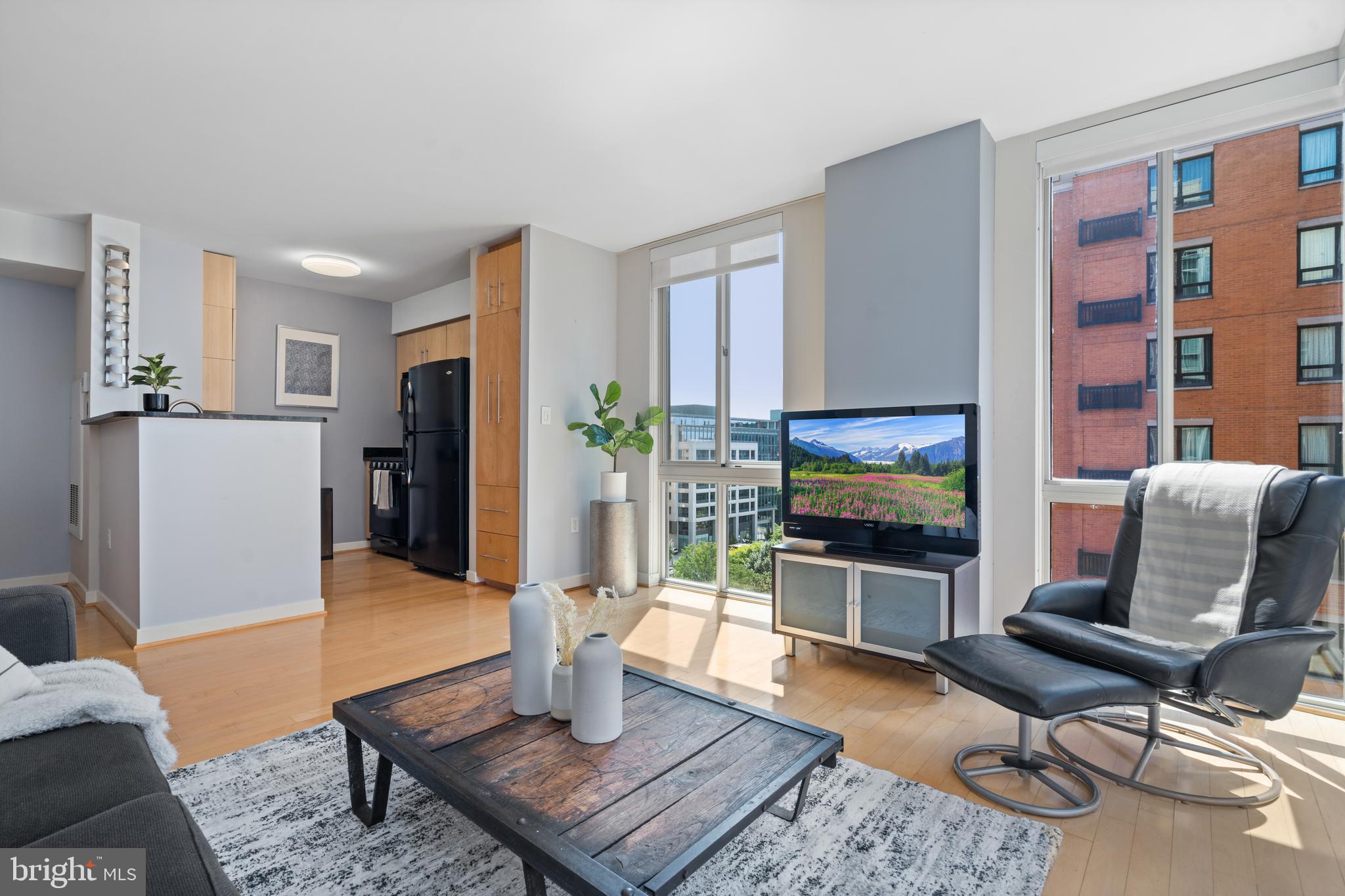 a living room with furniture a flat screen tv and a dining table