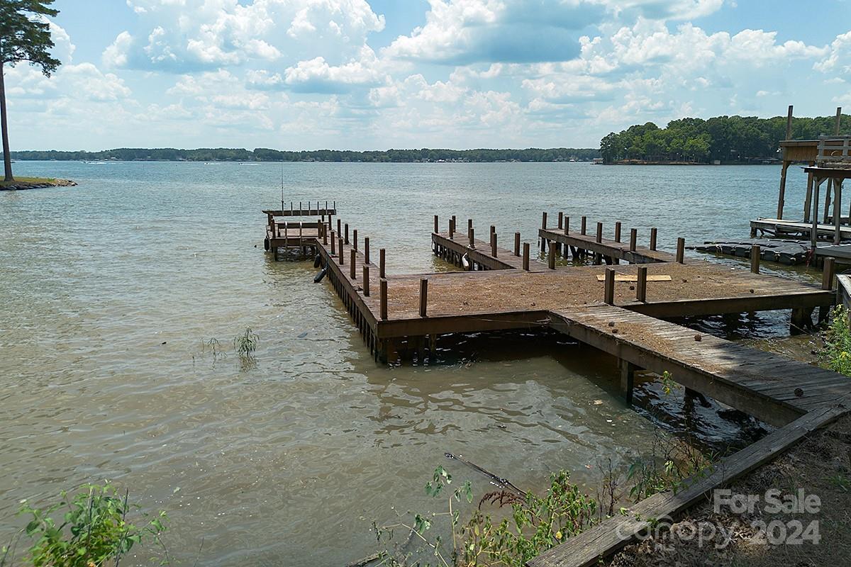 a view of a terrace with wooden benches and lake view