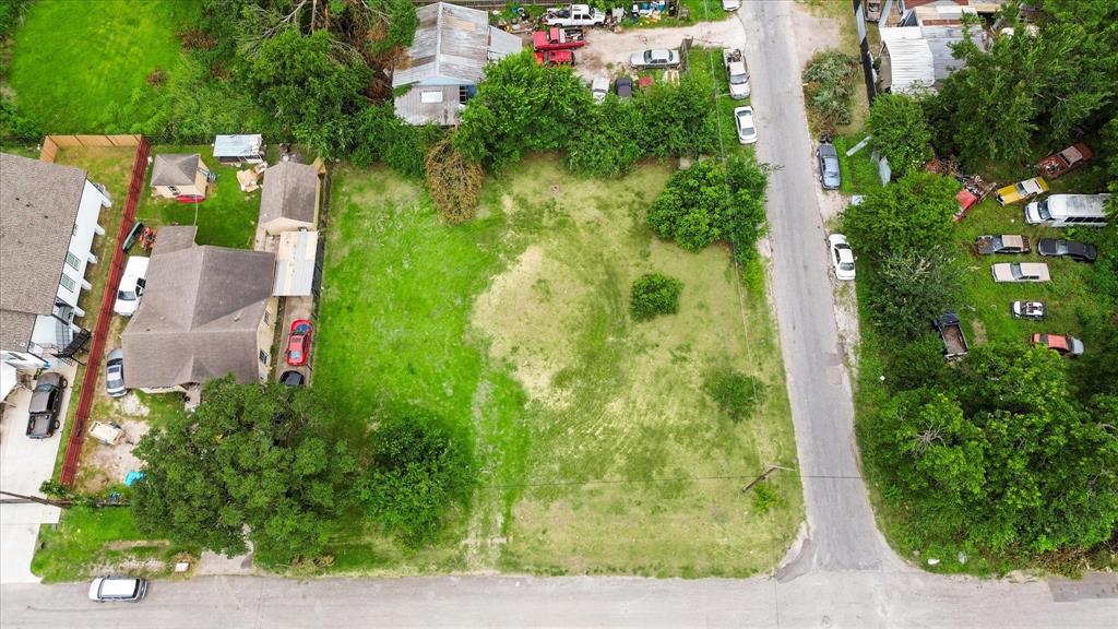 an aerial view of residential house with outdoor space and trees all around