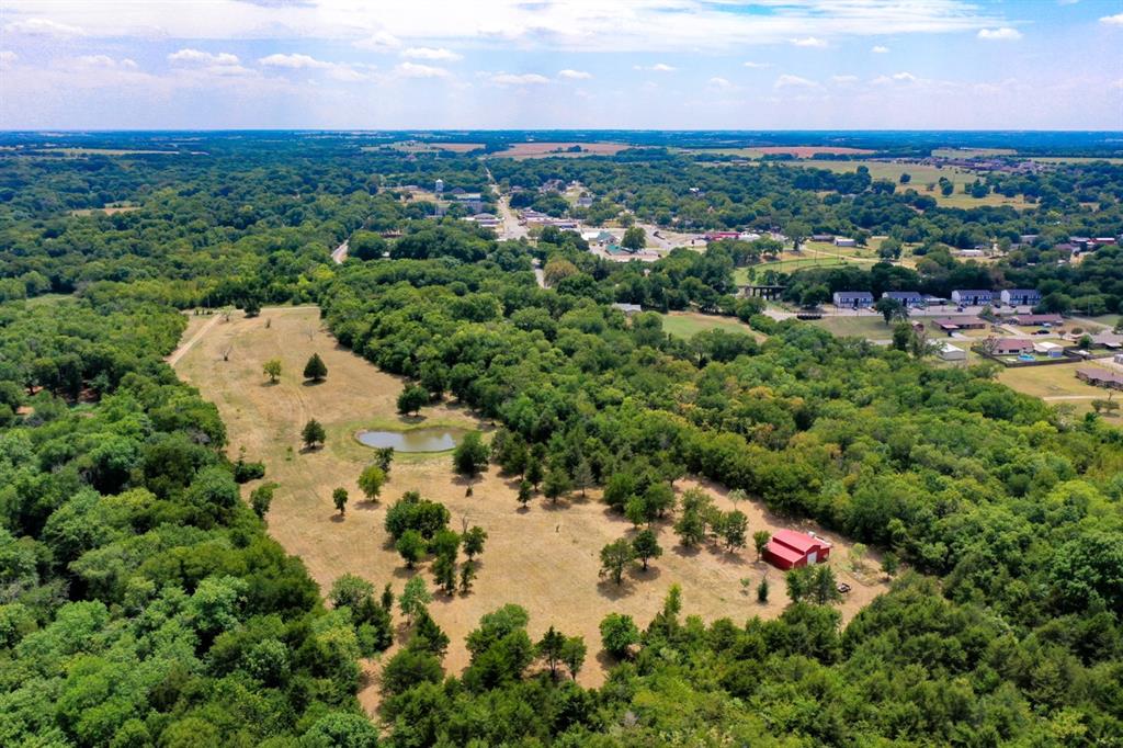 an aerial view of residential houses with outdoor space and trees