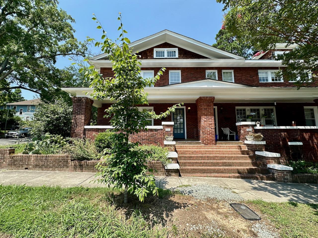 a front view of a house with garden and plants