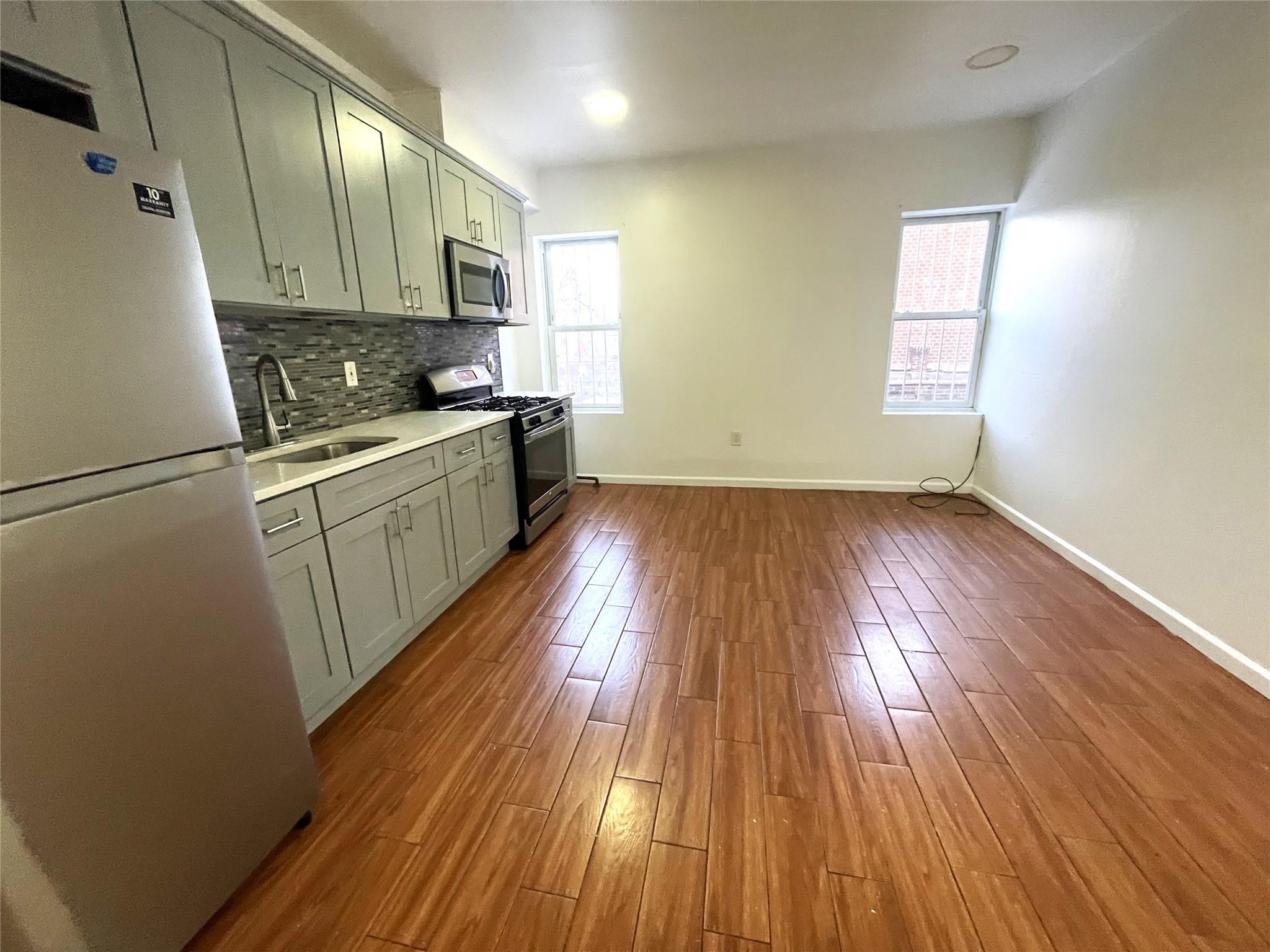 a kitchen with wooden floors and white appliances