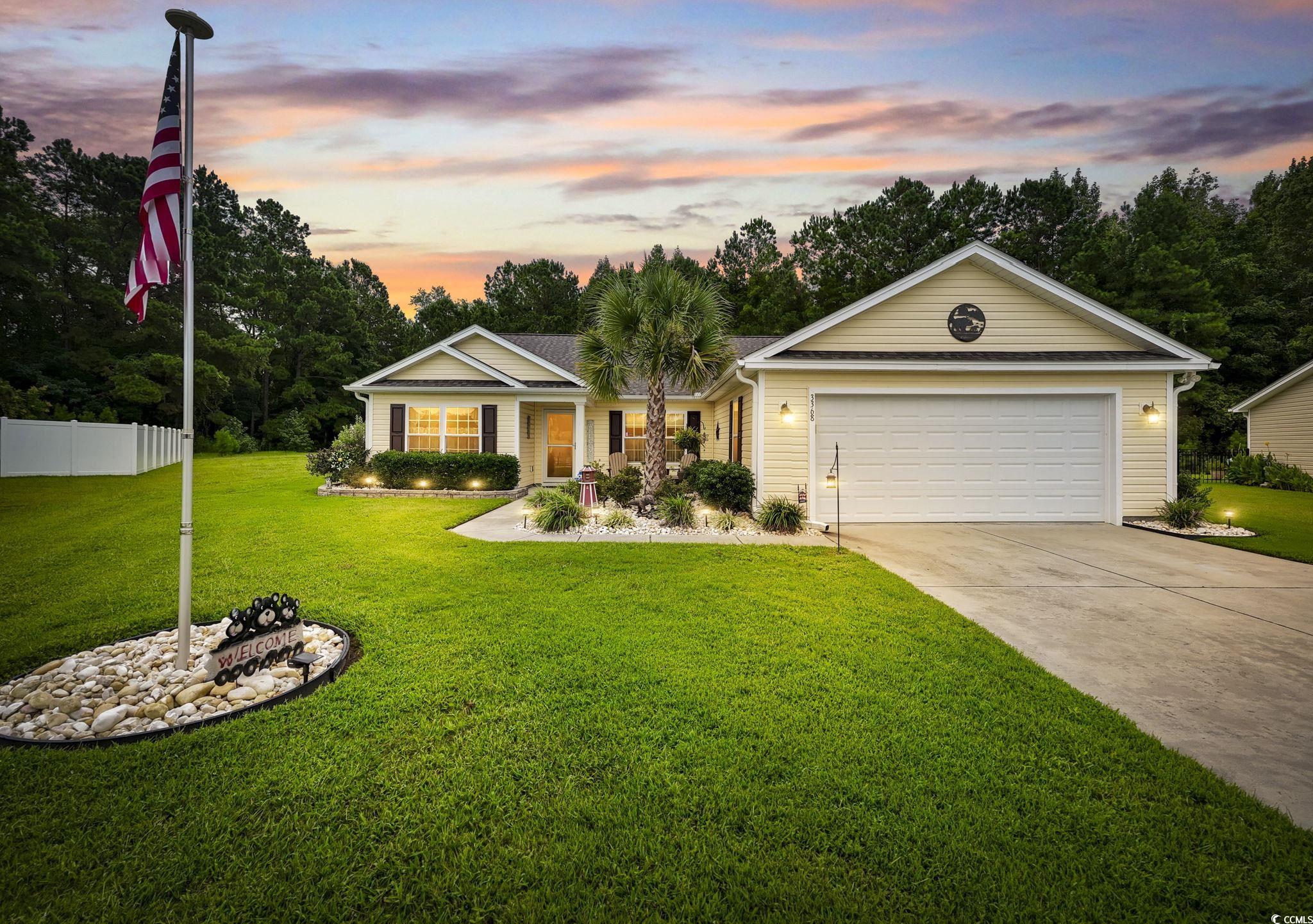 Ranch-style home featuring a garage and a lawn