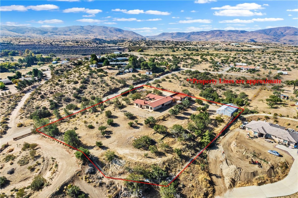 an aerial view of residential house with parking and city view