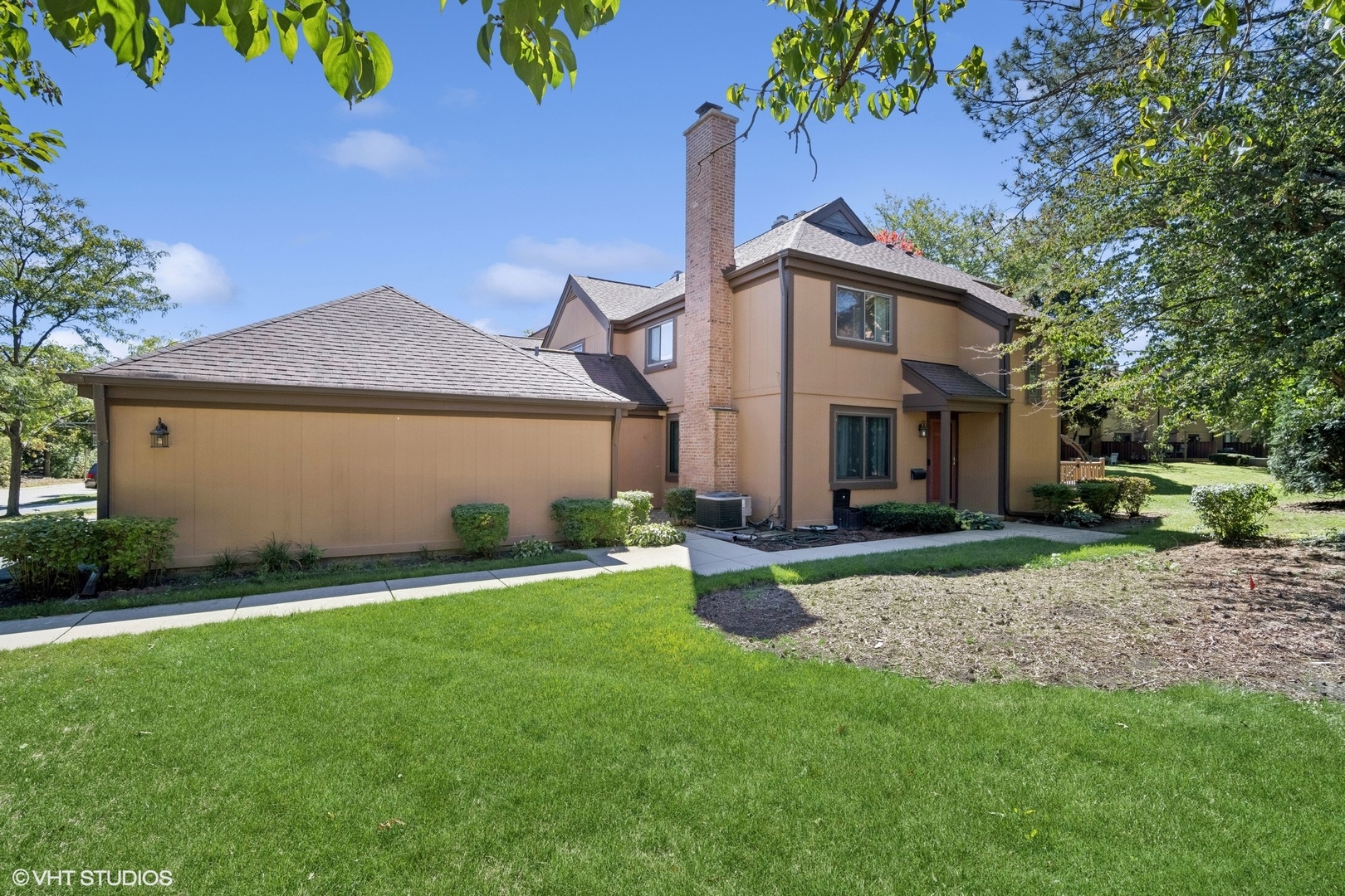 a front view of a house with a garden and yard