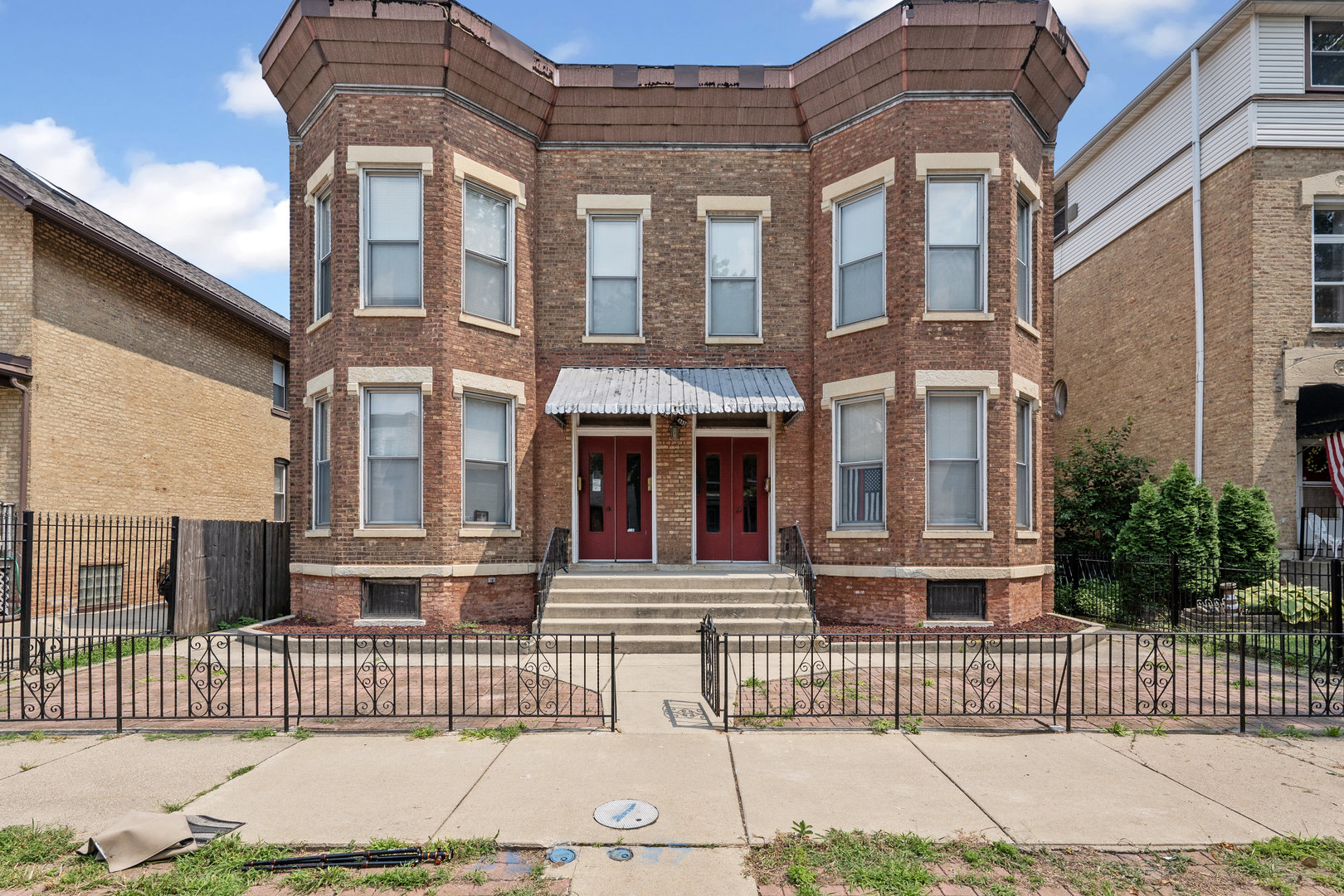 a front view of a brick house with a iron gate