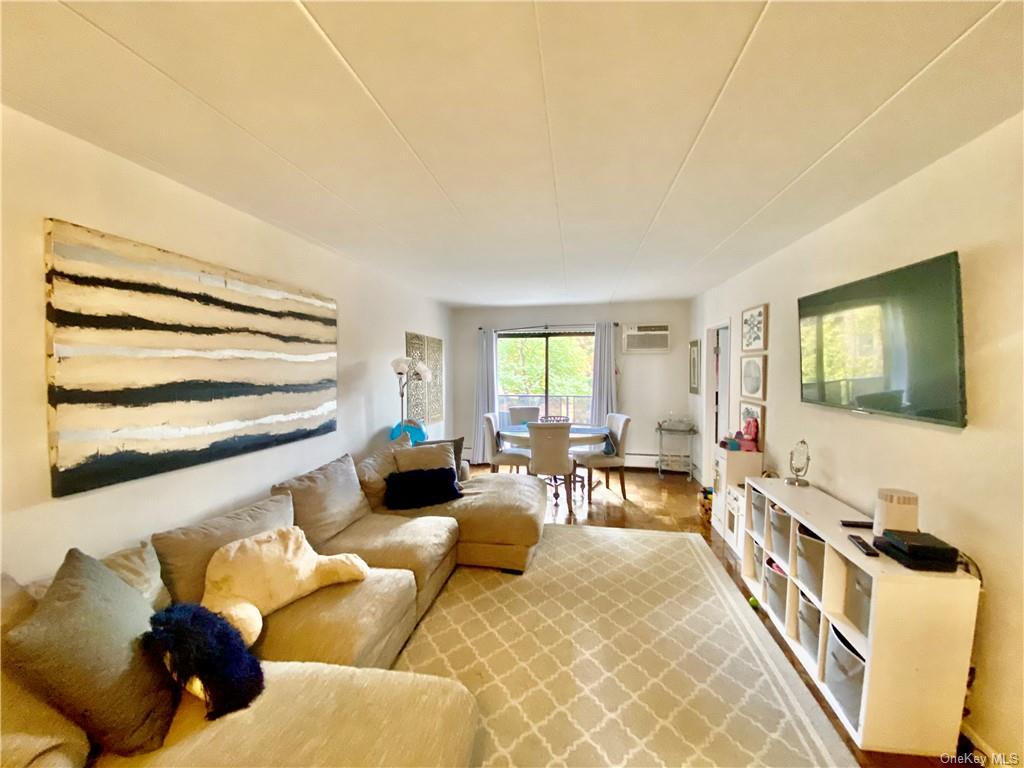 Living room with hardwood / wood-style flooring and a wall unit AC