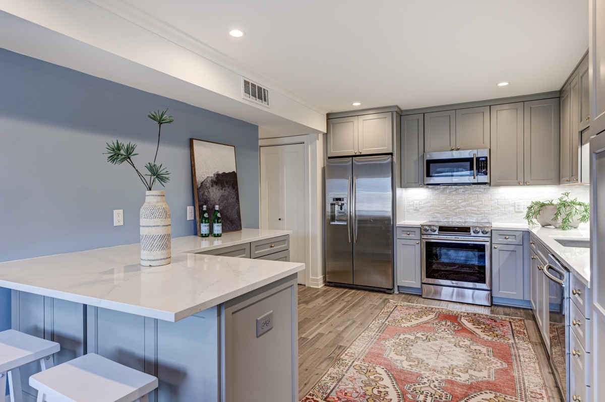 a kitchen with kitchen island a sink stainless steel appliances and cabinets