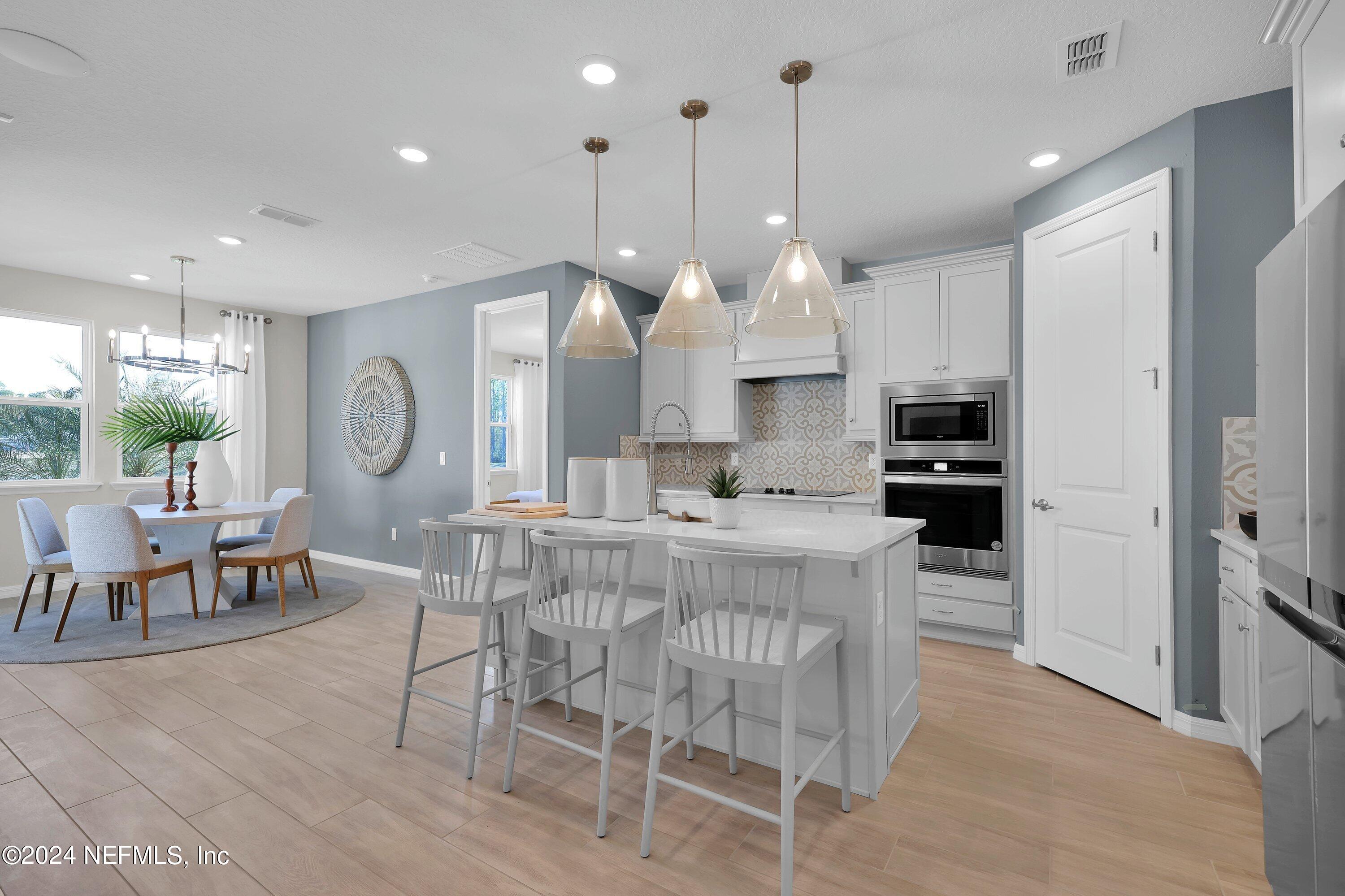 a large kitchen with a table and chairs