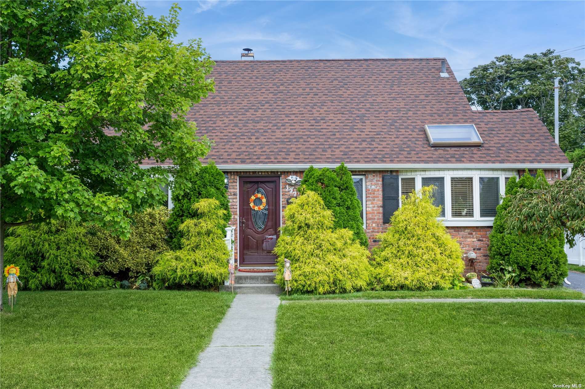 a front view of a house with a yard and trees