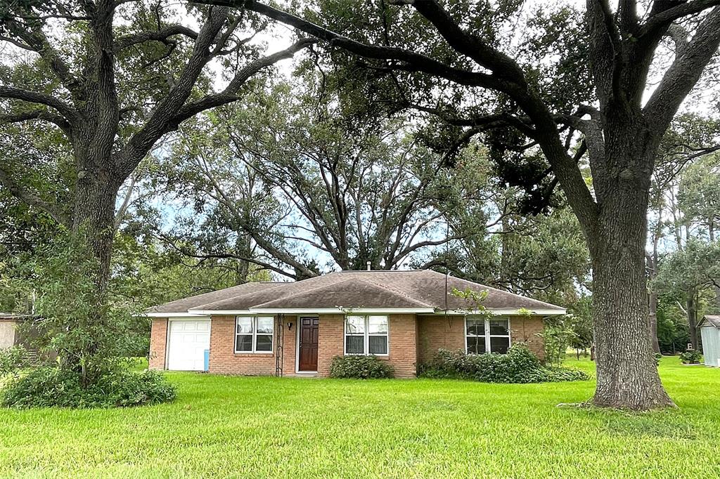 a white house with a tree in the grass