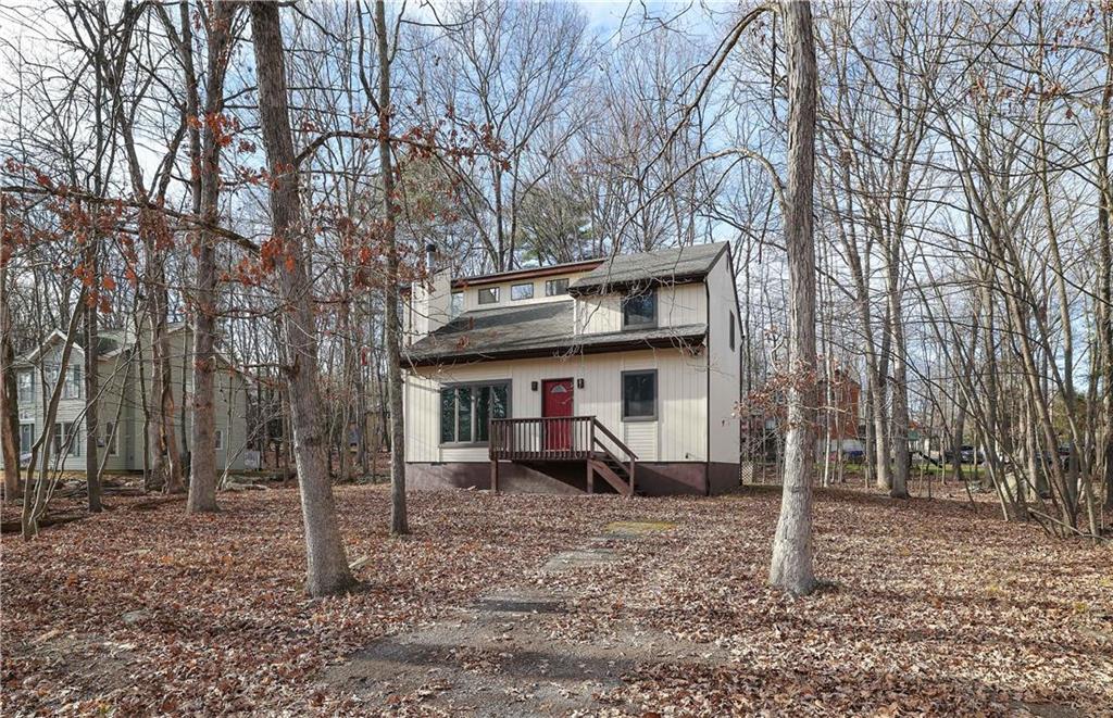 a view of a house with a large tree and wooden fence