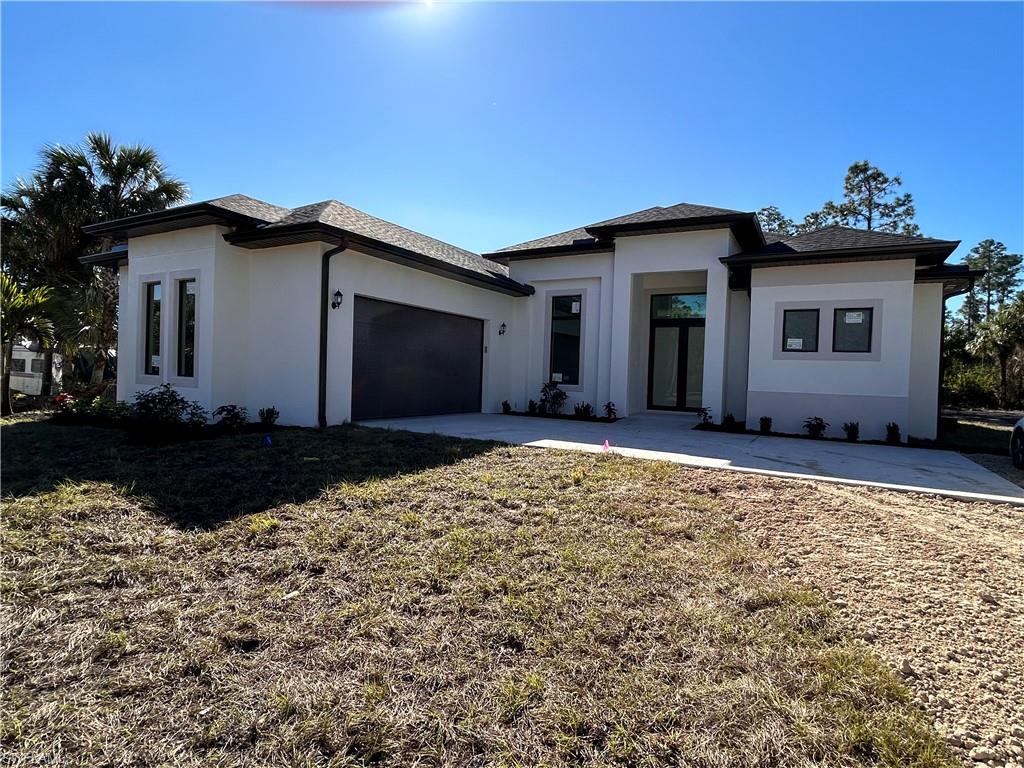 Prairie-style home with a garage and a front lawn