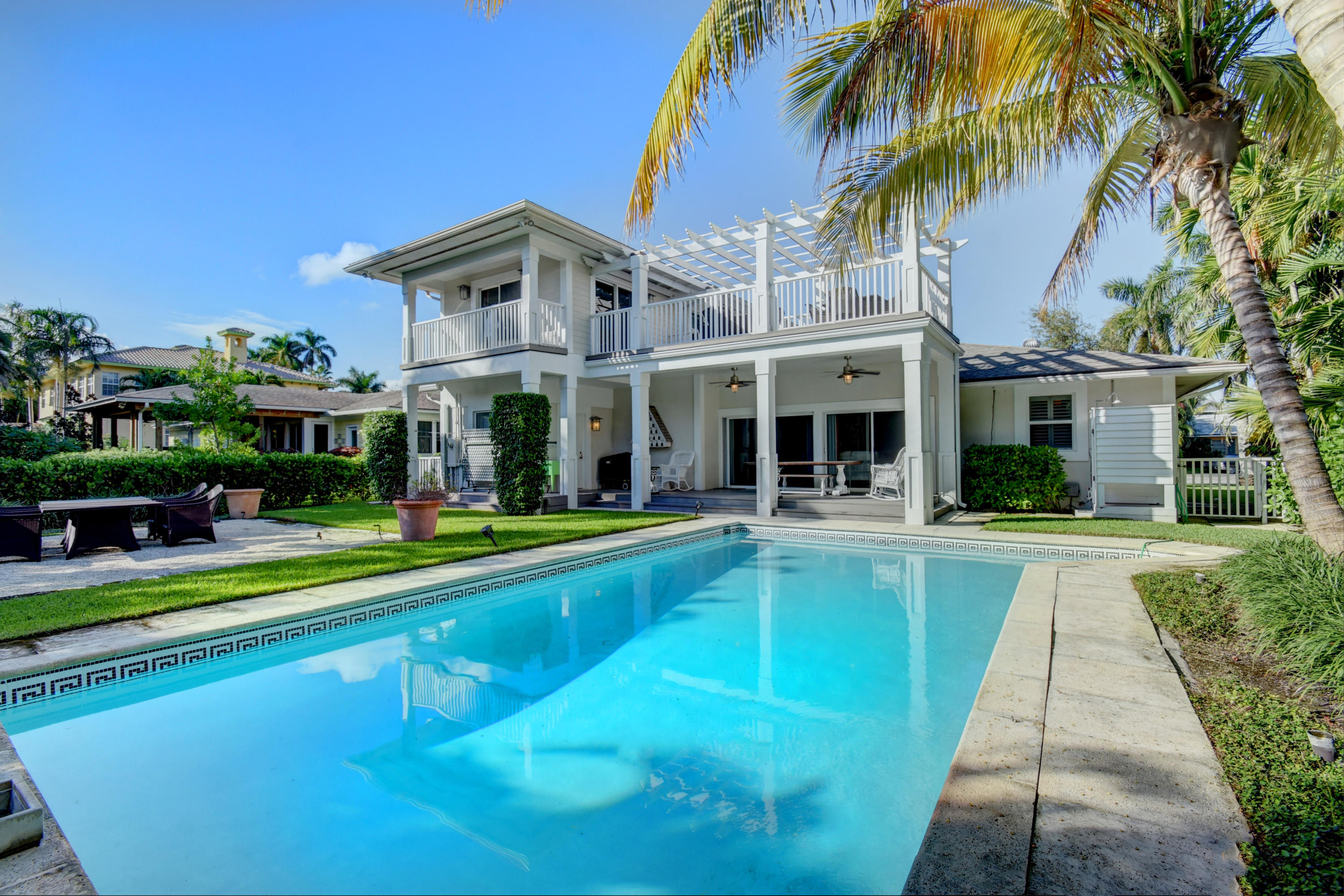 a view of house with swimming pool and a yard