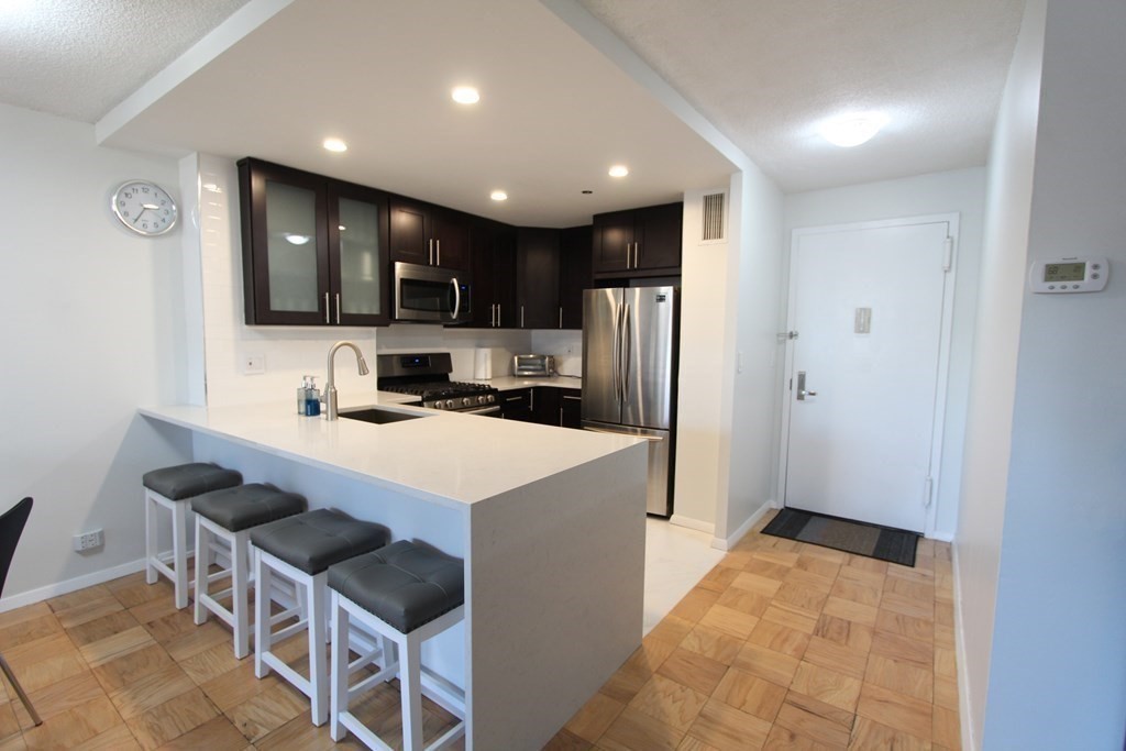 a kitchen with stainless steel appliances a refrigerator and a stove top oven