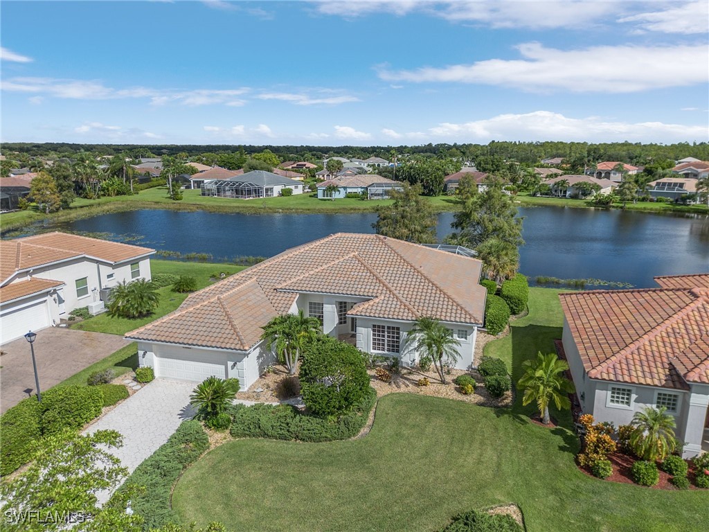 an aerial view of a house with swimming pool and lake view in back