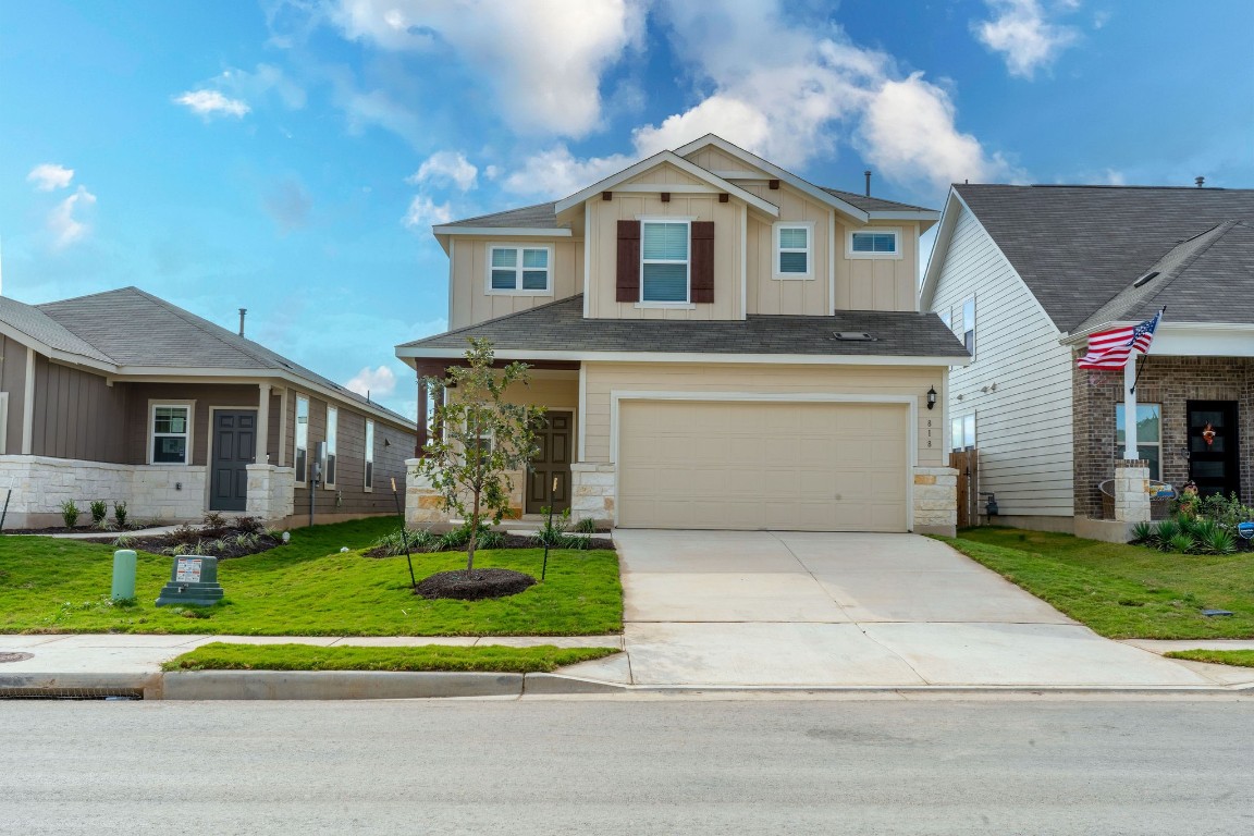 a front view of a house with a yard and garage