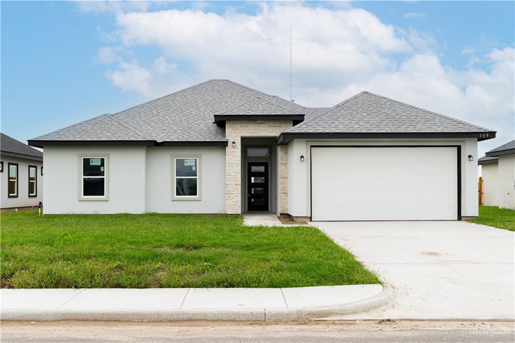 a front view of a house with a yard and garage