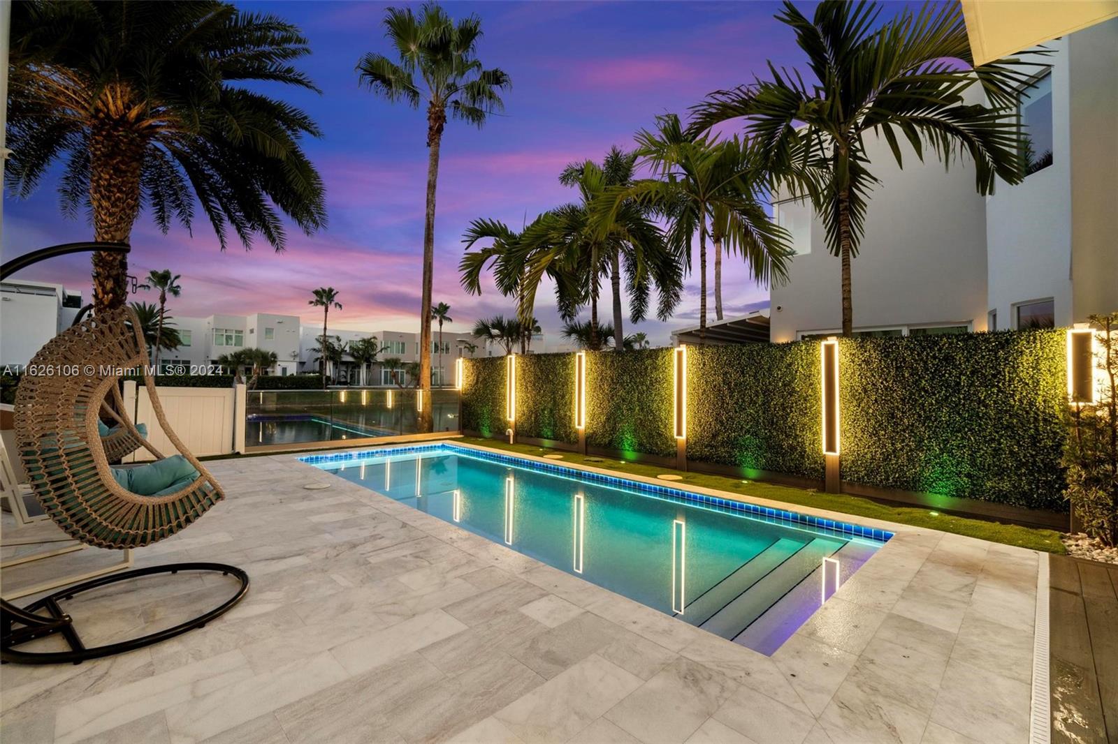 a view of a swimming pool with a chair and palm trees