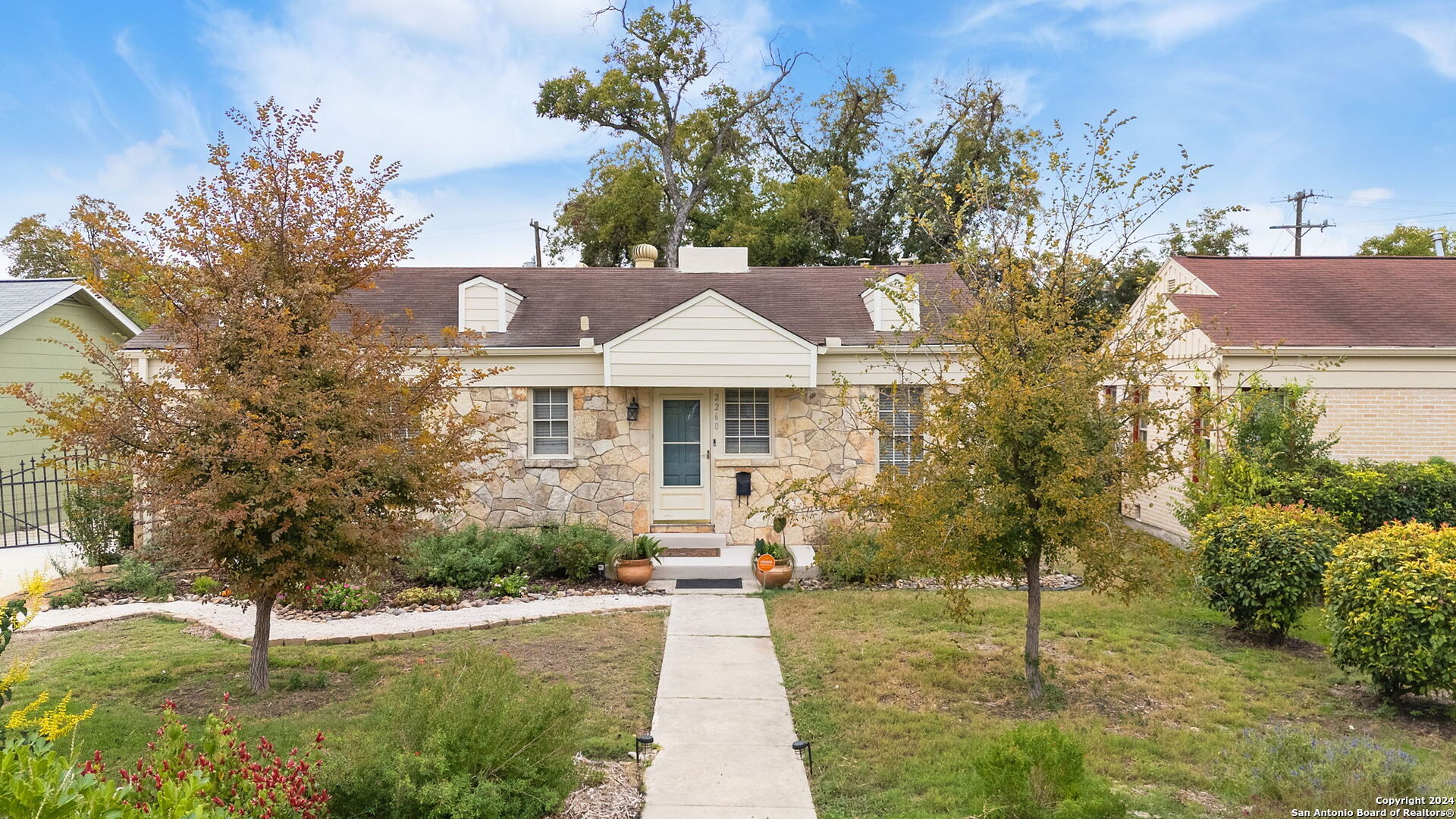 a front view of a house with a yard and trees