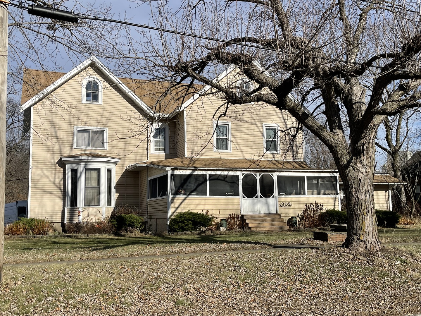 a view of a white house with large windows and a tree