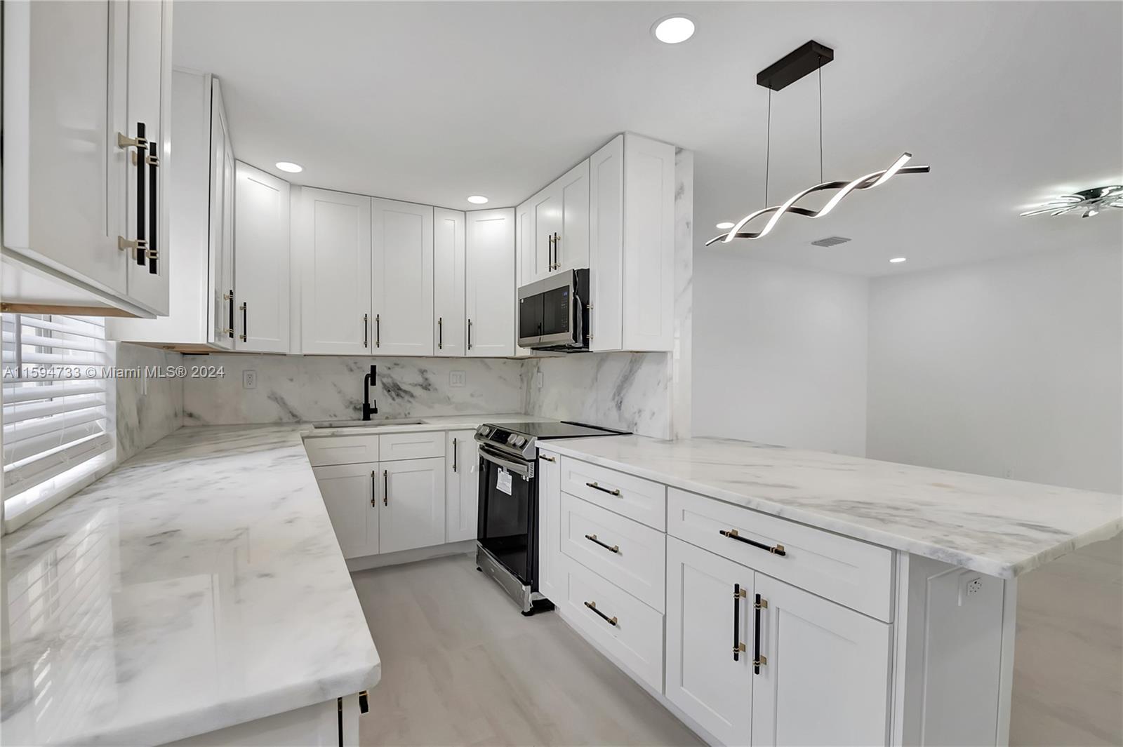 a kitchen with granite countertop white cabinets and white appliances