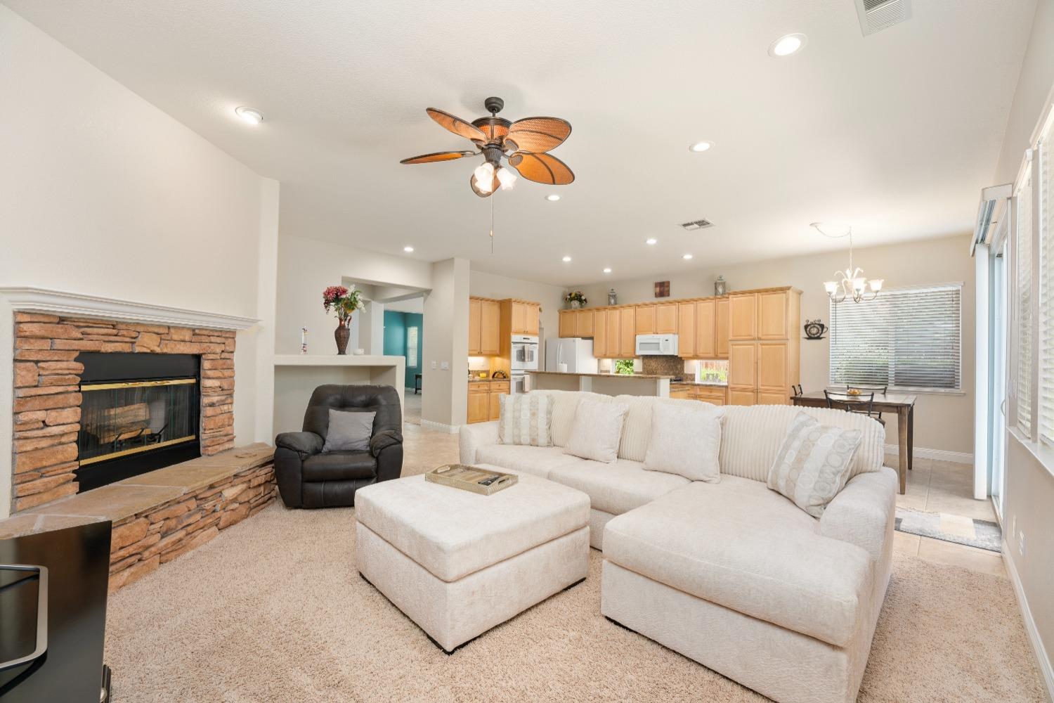 a living room with furniture a fireplace and a chandelier