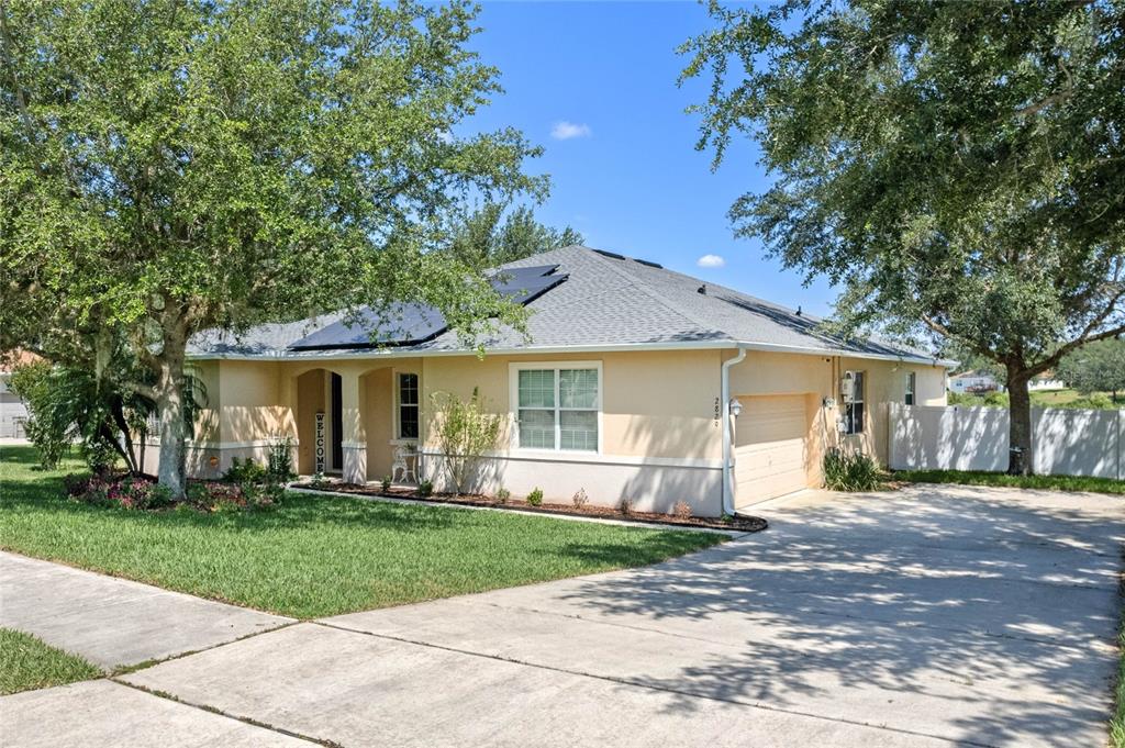 a front view of a house with a yard and trees