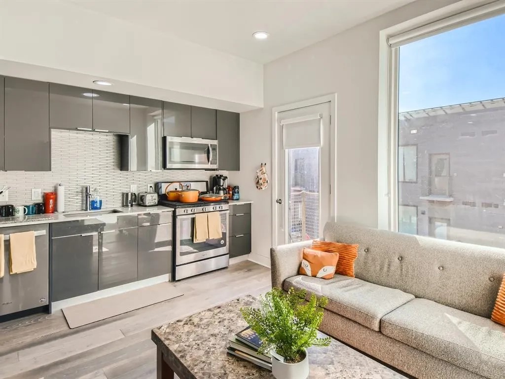 a living room with furniture and a kitchen counter space