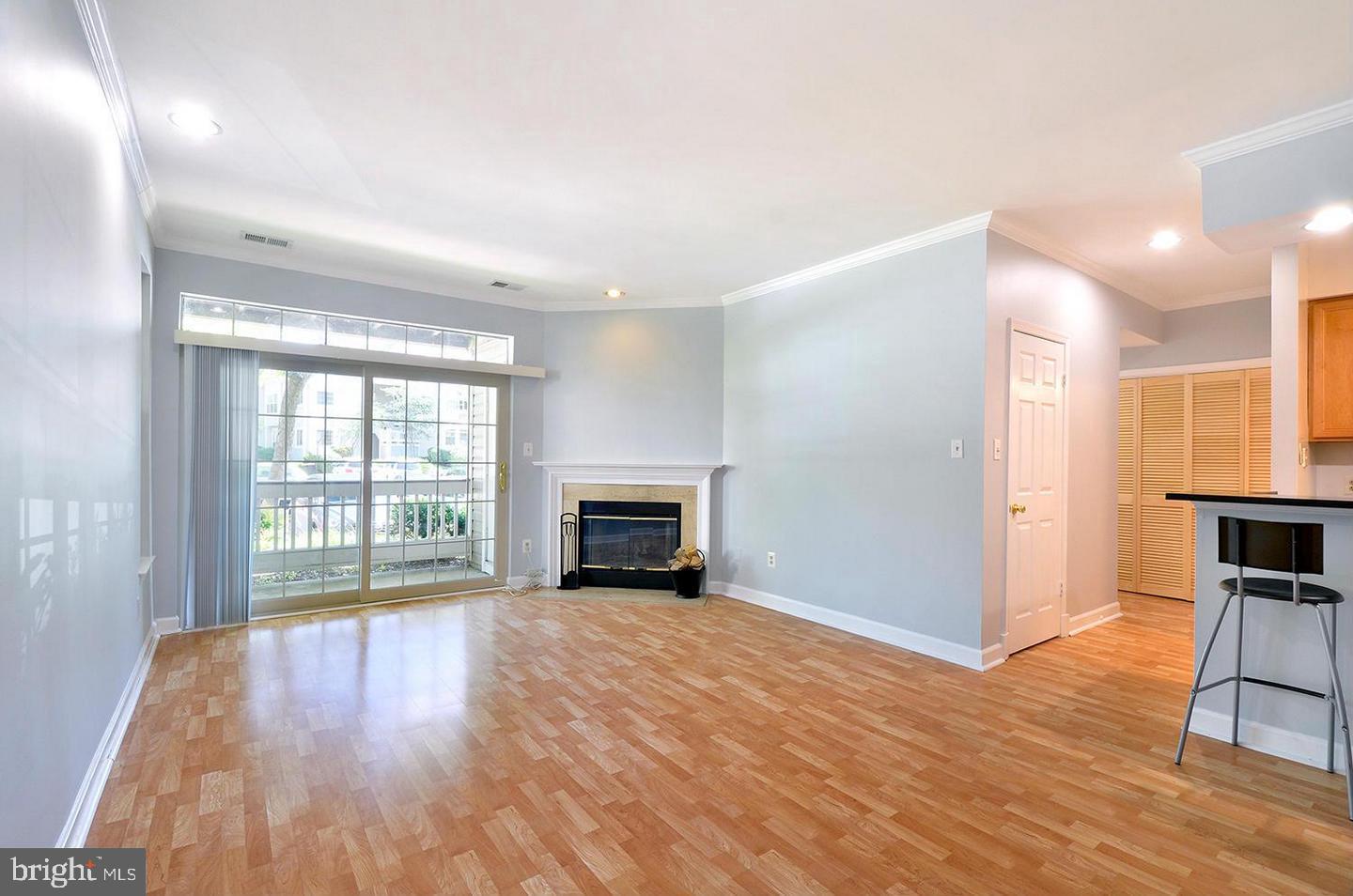 a view of empty room with wooden floor and fireplace