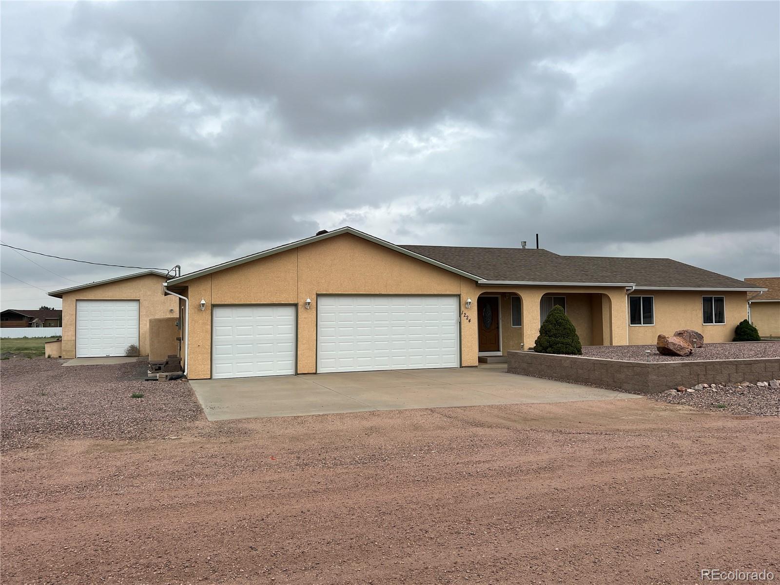 a view of house with backyard and parking space