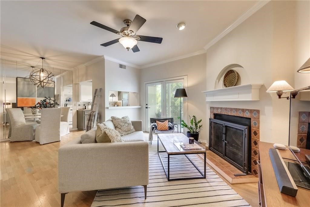 a living room with furniture a fireplace and a ceiling fan